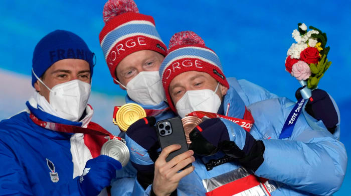 Norway's Johannes Thingnes Bø, center, and Tarjei Bø, right, pose for a selfie.